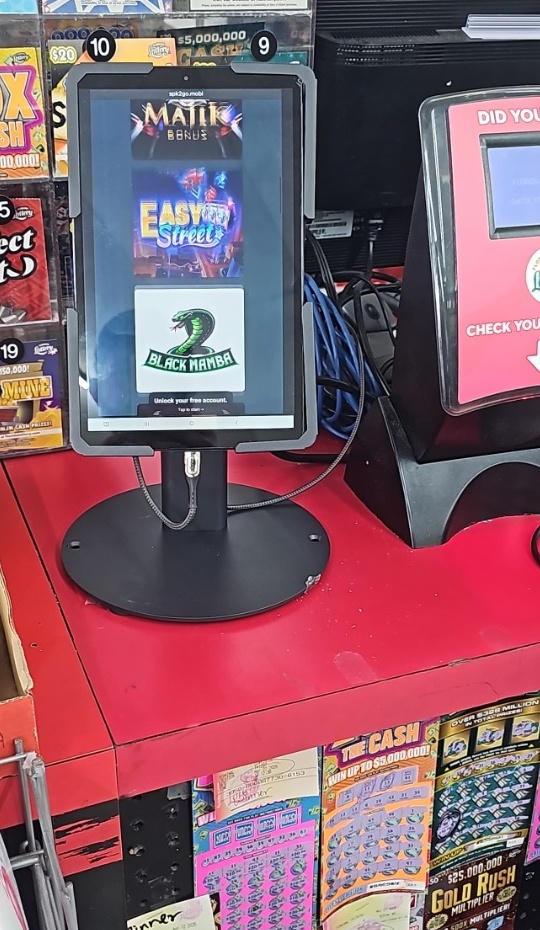 A NEMO LaunchPad tablet mounted on a countertop stand at a convenience store register